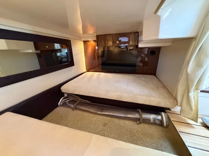 Slide: The Image of Interior of the 2013 Regal 35 Sport Coupe with cozy beds and wood accents. - 13