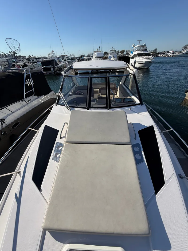 Slide: The Image of 2013 Regal 35 Sport Coupe: Sleek design with spacious sun deck, surrounded by yachts in a marina. - 18
