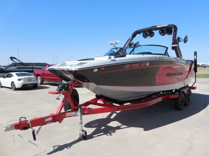Slide: The Image of A 2023 MasterCraft XStar S boat on a red trailer, parked on a concrete lot. - 7