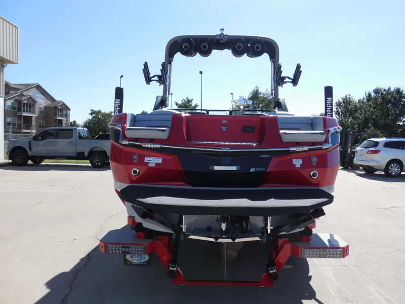 Slide: The Image of Red MasterCraft XStar S boat from the rear, parked with other vehicles. - 4