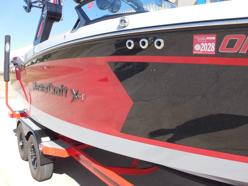 Slide: The Image of 2023 MasterCraft XStar S in red and black on a trailer. - 10