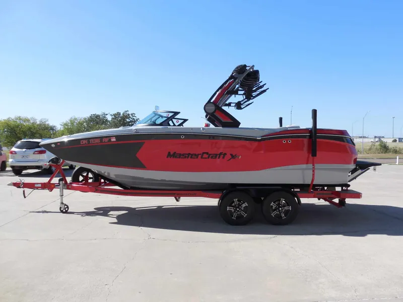 Slide: The Image of A 2023 MasterCraft XStar S boat on a trailer, painted in red and gray. - 6