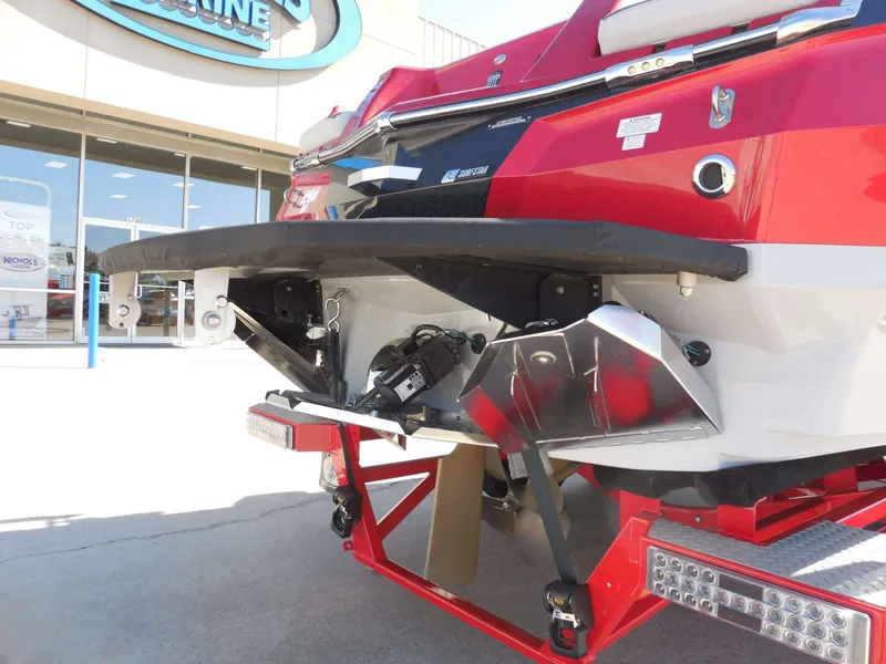 Slide: The Image of The image shows the stern of a 2023 MasterCraft XStar S boat with a red and white hull. - 12