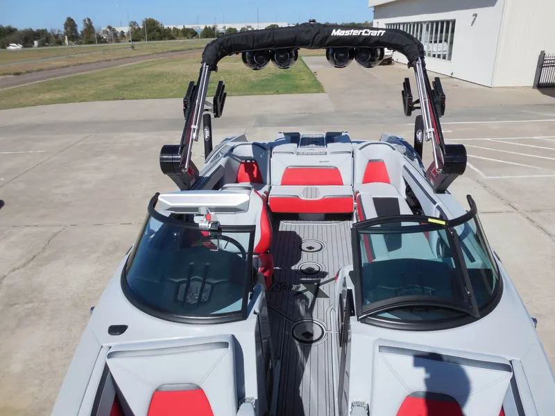 Slide: The Image of The image shows a 2023 MasterCraft XStar S boat with red and gray seats and a black wakeboard tower. - 23