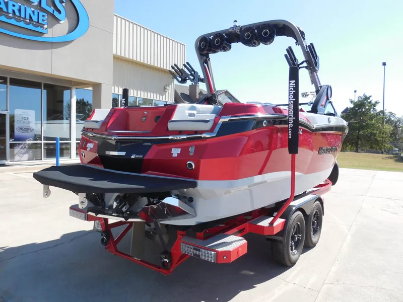 Slide: The Image of The image shows a red 2023 MasterCraft XStar S boat on a trailer in front of a building. - 3
