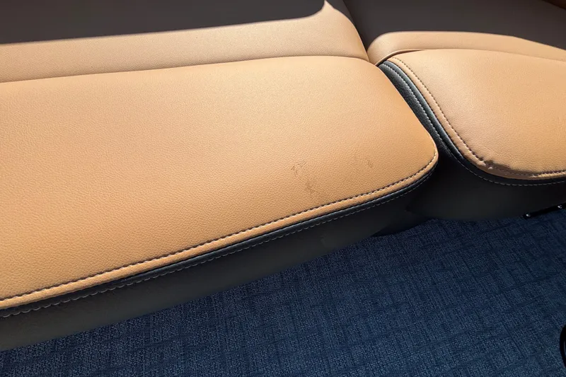 Slide: The Image of Tan leather seating in a 2027 Regency 230 DL3 boat, with subtle wear marks. - 10
