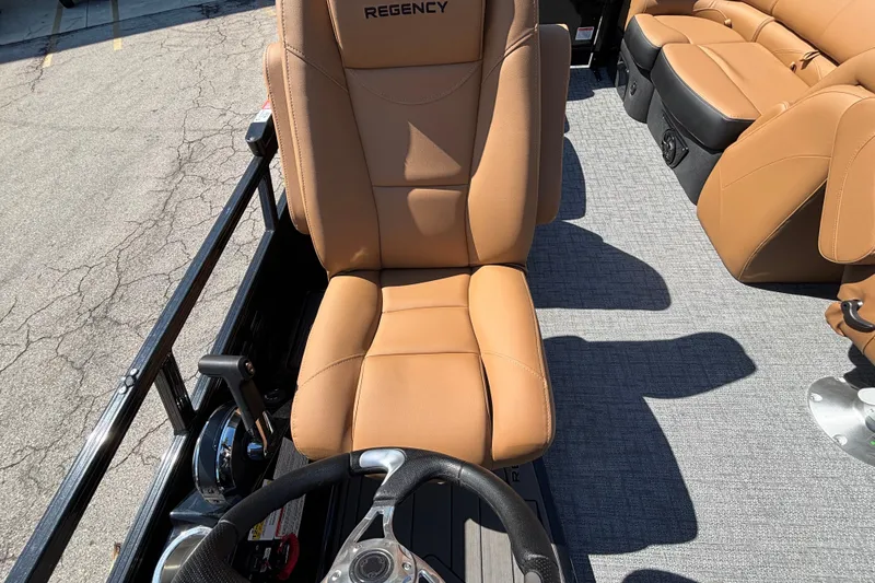 Slide: The Image of Captain's seat of 2027 Regency 230 DL3 pontoon boat with tan upholstery. - 9