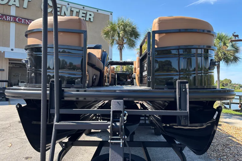 Slide: The Image of 2027 Regency 230 DL3 pontoon boat at dealership, featuring sleek design and tan seating. - 3
