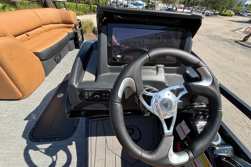 Slide: The Image of Steering wheel and dashboard of 2027 Regency 230 DL3 boat with tan seating. - 8