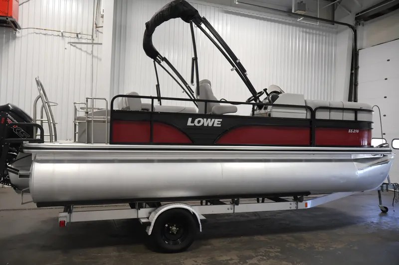 Slide: The Image of 2021 Lowe SS 210 CL pontoon boat in a garage setting. - 4