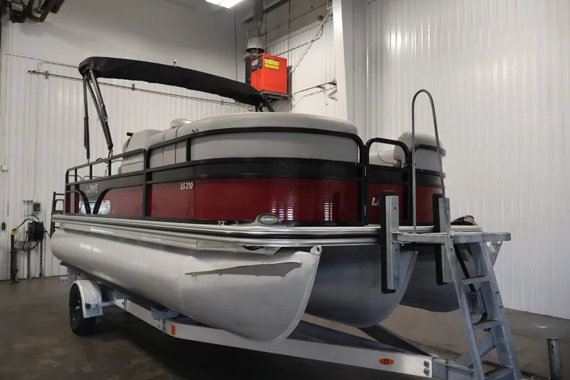 Slide: The Image of 2021 Lowe SS 210 CL pontoon boat in a garage on a trailer. - 3