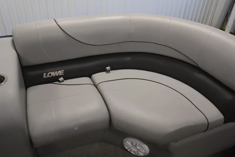 Slide: The Image of 2021 Lowe SS 210 CL boat interior with gray cushioned seating and branded logo. - 11
