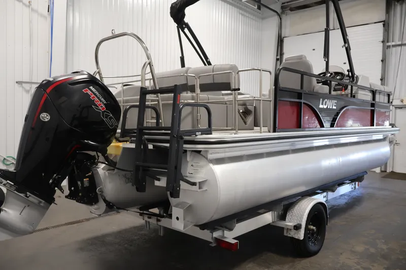 Slide: The Image of 2021 Lowe SS 210 CL pontoon boat with Mercury engine in indoor storage. - 5