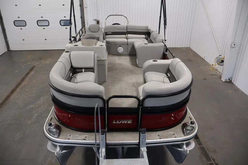 Slide: The Image of 2021 Lowe SS 210 CL pontoon boat with spacious seating in a garage setting. - 8