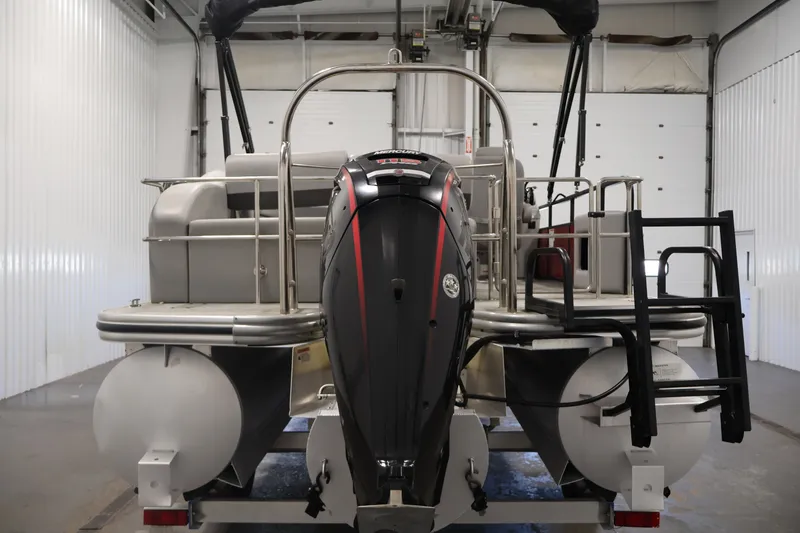 Slide: The Image of 2021 Lowe SS 210 CL pontoon boat with outboard motor in a garage setting. - 6