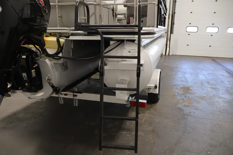Slide: The Image of 2021 Lowe SS 210 CL pontoon boat with ladder and motor in a garage. - 36
