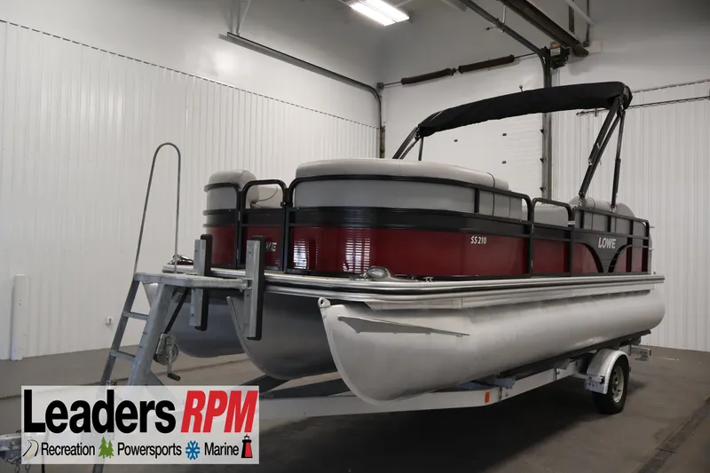 The Image of 2021 Lowe SS 210 CL pontoon boat on trailer in indoor showroom. - 0