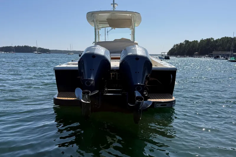 Slide: The Image of Rear view of a 2018 Hunt 32cc boat with dual outboard motors on a sunny day. - 6