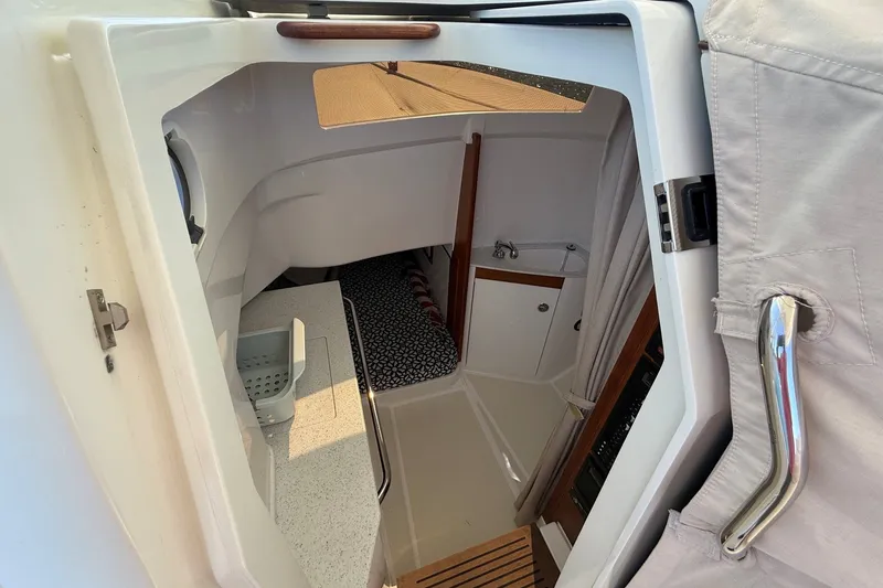Slide: The Image of Interior cabin of a 2018 Hunt 32cc boat, featuring a compact kitchenette and cozy sleeping area. - 35