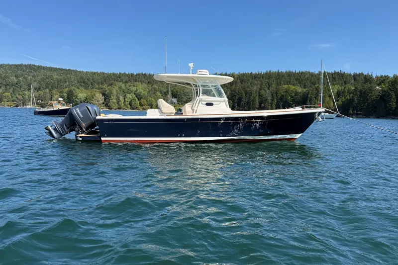 Slide: The Image of 2018 Hunt 32cc boat on calm water, surrounded by lush green forest. - 4