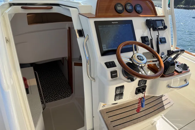 Slide: The Image of 2018 Hunt 32cc boat cockpit with steering wheel, navigation system, and control panel. - 9