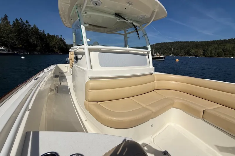 Slide: The Image of 2018 Hunt 32cc boat with tan seating, cruising on a scenic lake. - 31