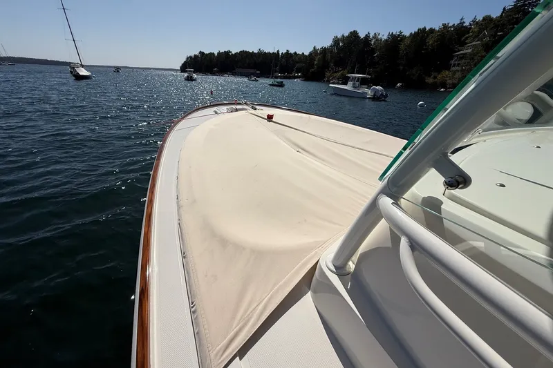 Slide: The Image of 2018 Hunt 32cc boat on calm water, surrounded by other boats and scenic shoreline. - 33