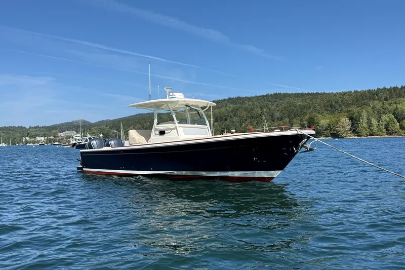 Slide: The Image of 2018 Hunt 32cc boat anchored on scenic blue water with forested shoreline. - 1