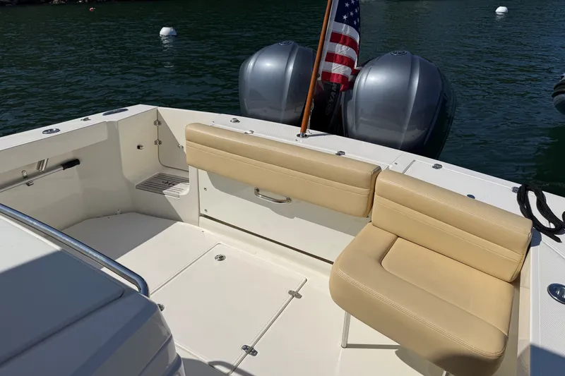 Slide: The Image of 2018 Hunt 32cc boat with beige seating, dual engines, and American flag on calm water. - 18