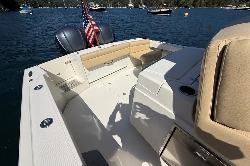 Slide: The Image of 2018 Hunt 32cc boat interior with seating, American flag, and twin engines on a sunny day. - 16