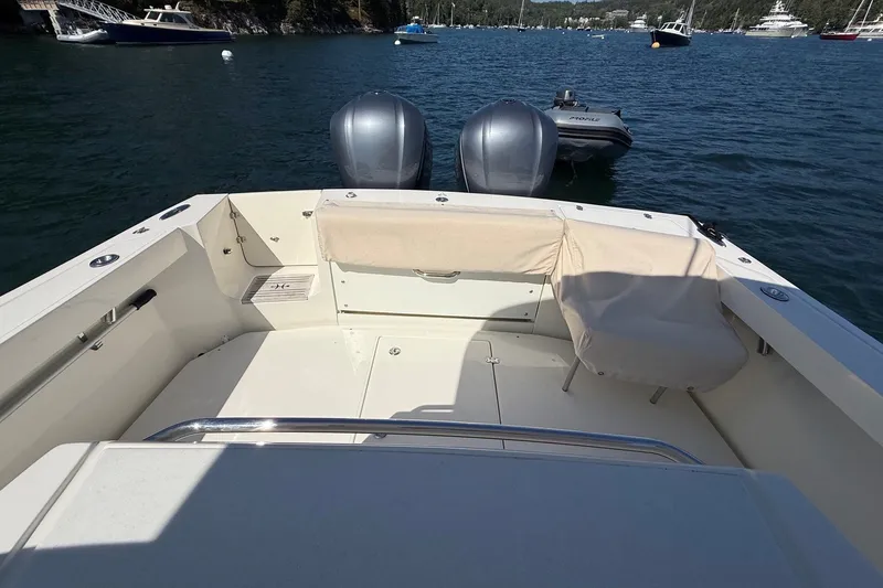 Slide: The Image of 2018 Hunt 32cc boat interior with dual engines, docked in a scenic harbor. - 24