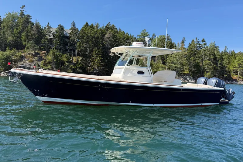 The Image of 2018 Hunt 32cc boat on water, surrounded by lush forested shoreline. - 0