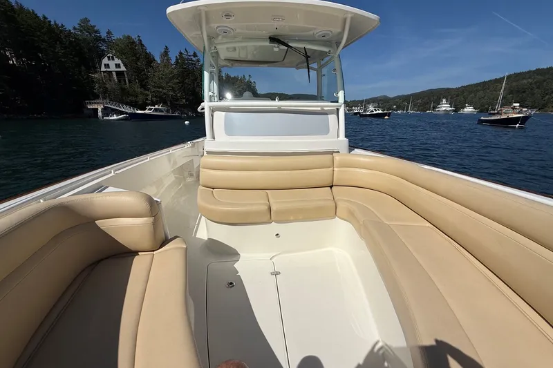 Slide: The Image of 2018 Hunt 32cc boat with tan seating, docked in a scenic harbor. - 30