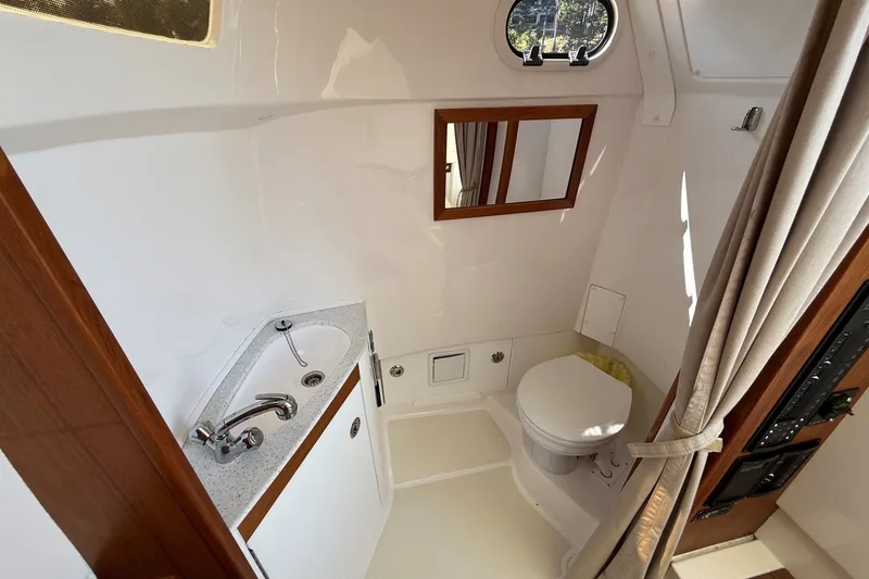 Slide: The Image of Compact boat bathroom with sink, toilet, mirror, and porthole in 2018 Hunt 32cc model. - 38