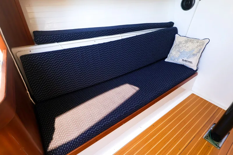 Slide: The Image of Interior of 2014 J Boats J/111 with navy cushioned seating and nautical-themed pillow. - 35