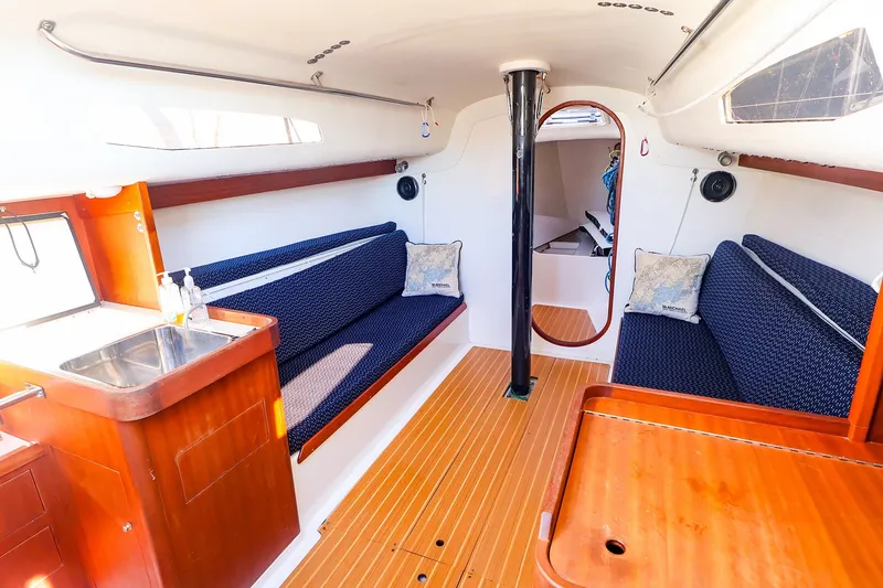 Slide: The Image of Interior of 2014 J Boats J/111 sailboat with wooden flooring and blue seating. - 28