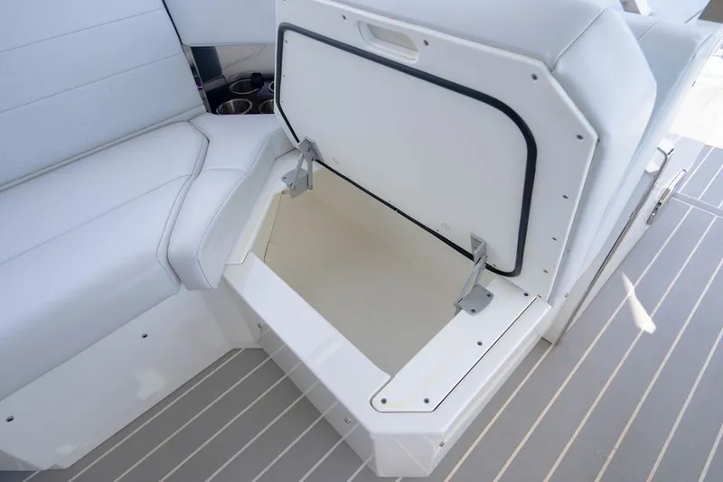 Slide: The Image of 2025 Formula 500 Super Sport Crossover boat interior storage compartment, open with white seating. - 69