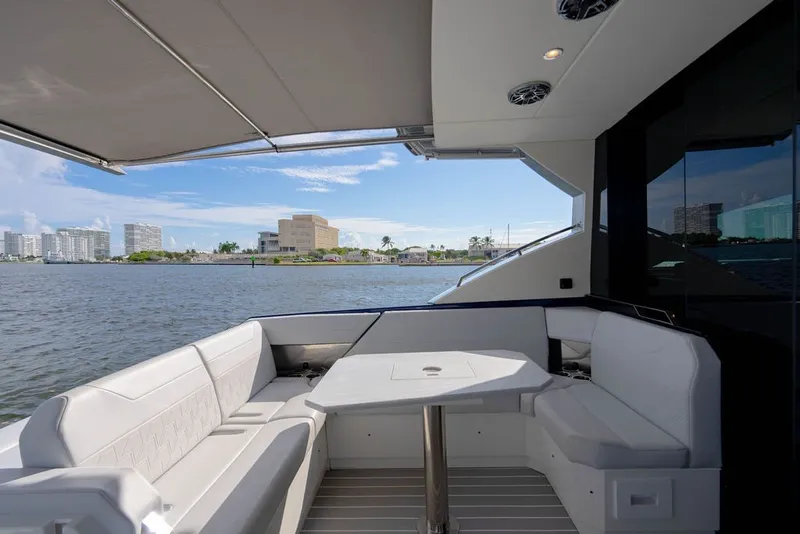 Slide: The Image of Luxury seating area on 2025 Formula 500 Super Sport Crossover yacht, overlooking waterfront cityscape. - 74