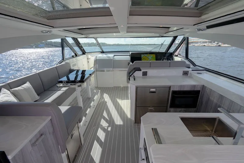 Slide: The Image of 2025 Formula 500 Super Sport Crossover yacht interior with modern seating and kitchen area. - 80
