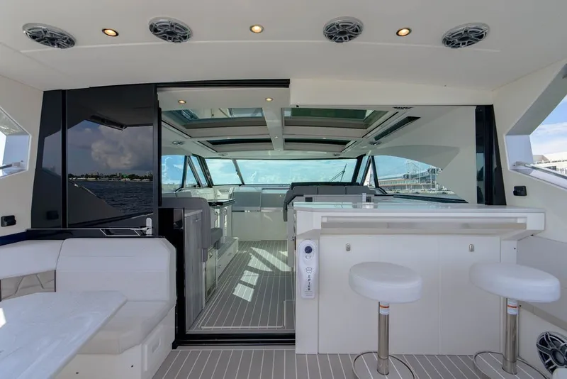 Slide: The Image of Luxurious interior of 2025 Formula 500 Super Sport Crossover yacht with modern seating and bar area. - 76