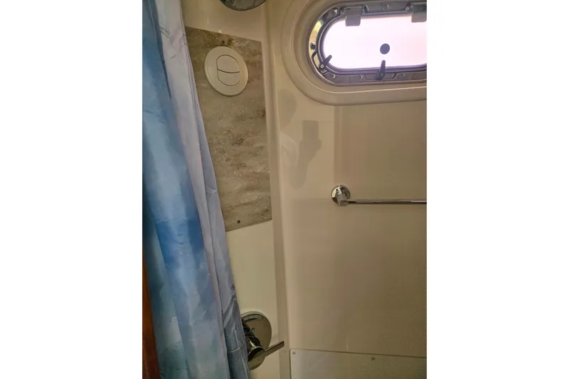 Slide: The Image of Interior of 2018 Pursuit S 368 Sport boat bathroom with window and shower curtain. - 16
