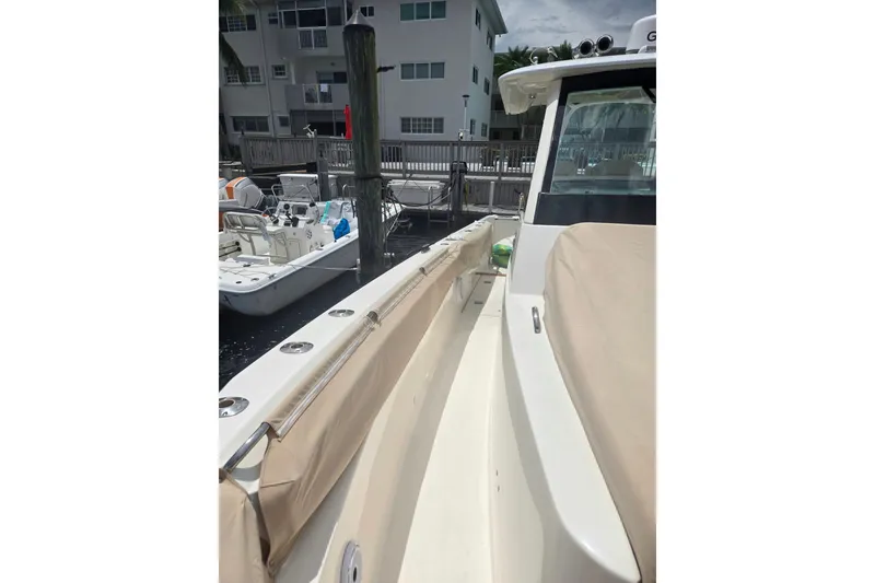 Slide: The Image of 2018 Pursuit S 368 Sport boat docked, featuring beige seating and sleek design. - 28