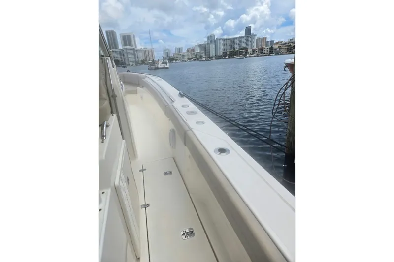 Slide: The Image of 2018 Pursuit S 368 Sport boat docked by waterfront cityscape. - 27