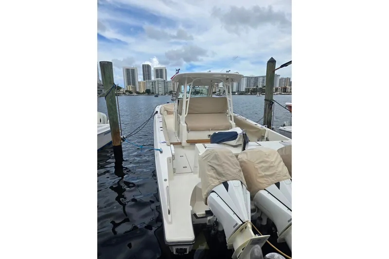 Slide: The Image of 2018 Pursuit S 368 Sport boat docked with city skyline in background. - 17