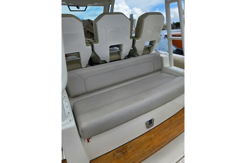 Slide: The Image of 2018 Pursuit S 368 Sport boat seating with beige upholstery and wooden flooring. - 21