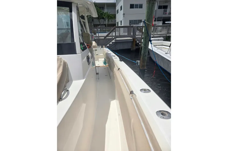 Slide: The Image of 2018 Pursuit S 368 Sport boat docked, showcasing sleek design and spacious deck. - 14
