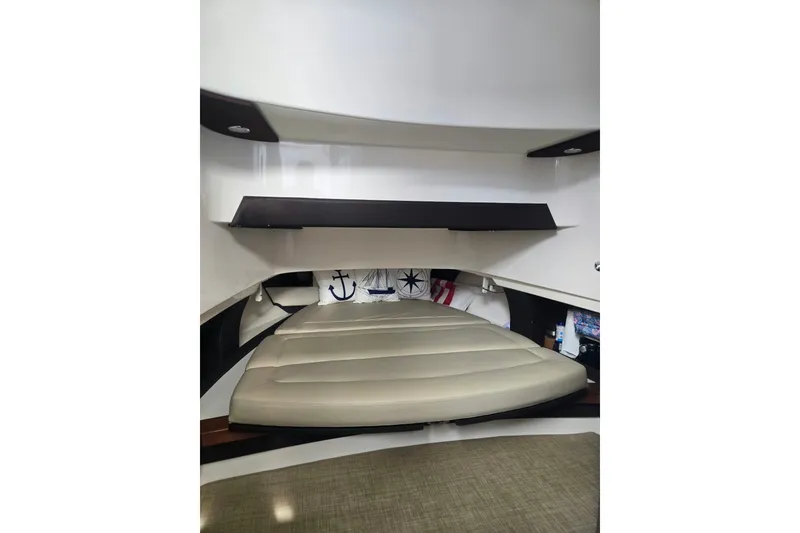 Slide: The Image of 2018 Pursuit S 368 Sport cabin interior with cushioned seating and nautical decor. - 31