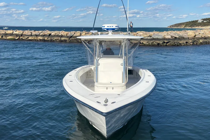 Slide: The Image of 2003 Venture 34 Open boat on calm water near rocky shoreline. - 3