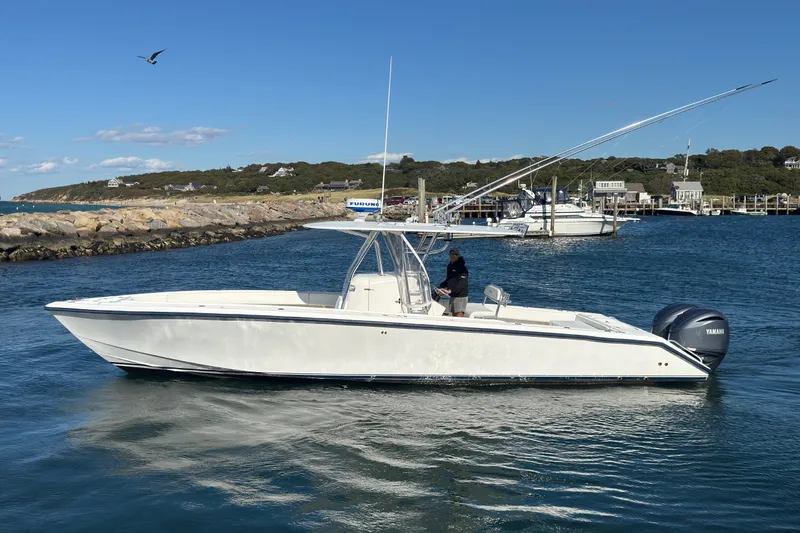 Slide: The Image of 2003 Venture 34 Open boat cruising in a scenic harbor with clear blue skies. - 5