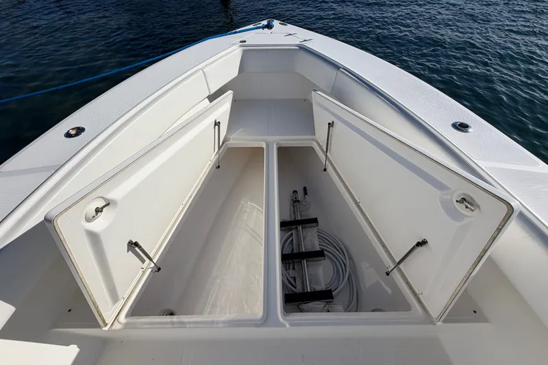 Slide: The Image of 2003 Venture 34 Open boat storage compartments with open hatches, docked on calm water. - 13